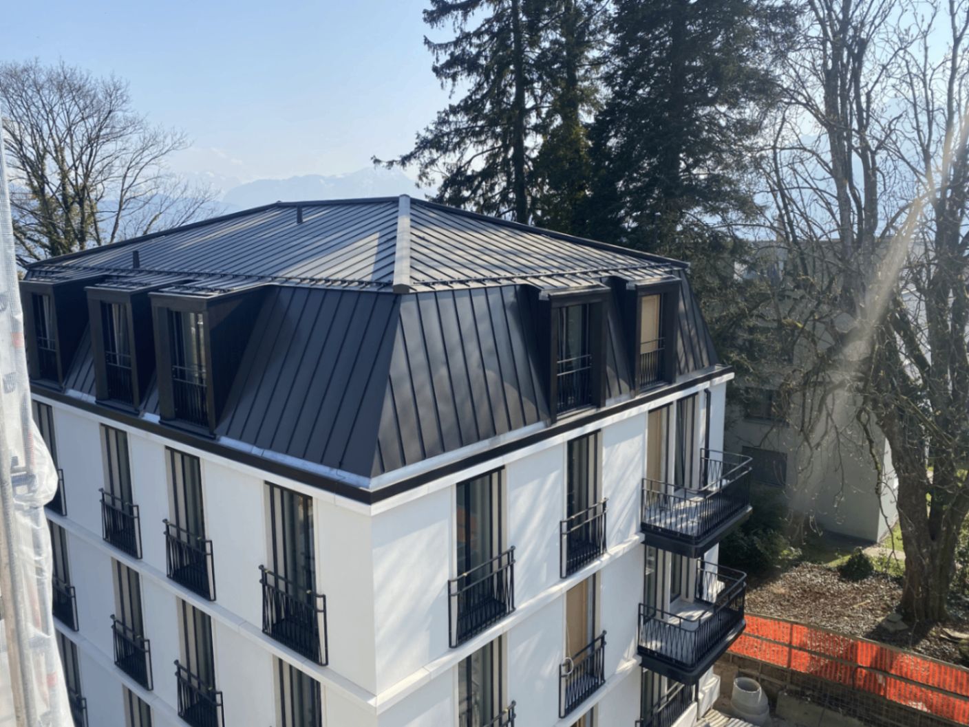 Mehrfamilienhaus mit dunklem Metall-Mansardendach